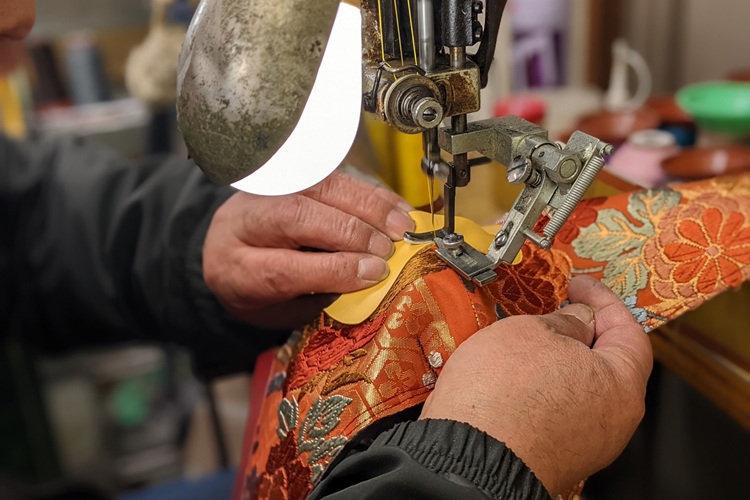 将加强的和服固定在内底的缝制工序。小心操作以避免松弛