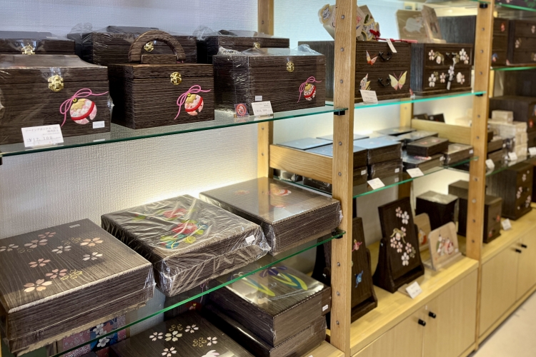 店前陈列的针线盒和文具盒等桐木制品。手工艺品的图案有铃铛、蝴蝶、樱花等,很受欢迎